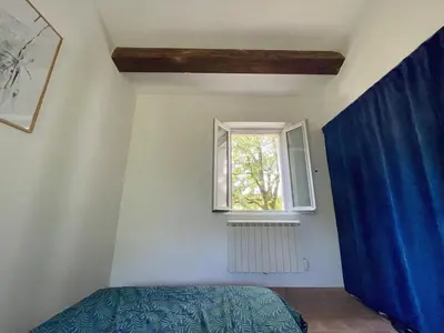 a bedroom with a bed and a window at La Régalade in Le Puy-Sainte-Réparade