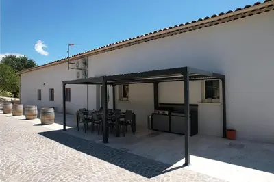 a pavilion with a table and chairs next to a building at Luxury air-conditioned villa pool views Aix-en-Provence LS7-457 in Saint-Cannat
