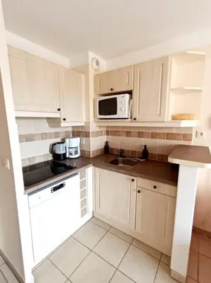 a kitchen with white cabinets and a sink and a microwave at Domaine de Pont royal in Mallemort