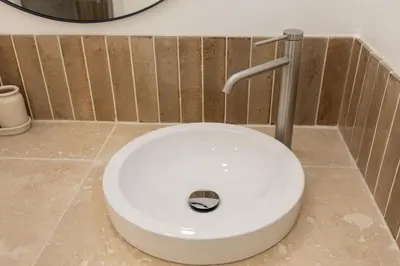 a white toilet in a bathroom with a wall at Suite Lueur de Sable - Hypercentre - WiFi in Apt
