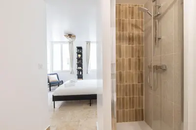a bathroom with a shower and a bed in a room at Suite Lueur de Sable - Hypercentre - WiFi in Apt