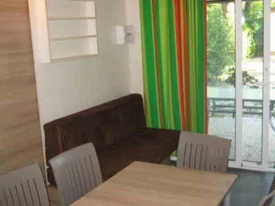 a living room with a couch and a table and chairs at Chalet 46m² avec Terrasse à Noves - API-1-52-531 in Noves