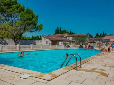 a swimming pool with people playing in the water at Chalet 3 pièces avec terrasse, 4 pers, confort et calme - API-1-52-742 in Noves