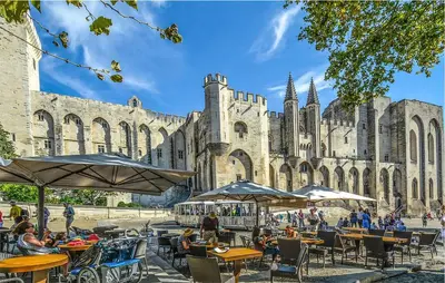 people sitting at tables in front of a building at Proche Alpilles in Eyragues