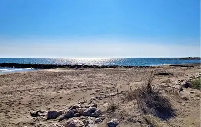 a sandy beach with rocks and the ocean at Proche Alpilles in Eyragues