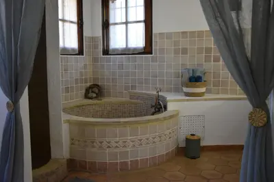 a bathroom with a tub in a room with windows at Les Chambres du Luberon & Table d'hôtes in Lauris