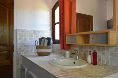 a bathroom counter with a sink and a mirror at Les Chambres du Luberon & Table d'hôtes in Lauris