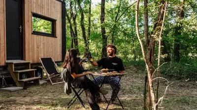 a man and woman sitting at a table with wine glasses at Homnest - Infusion Provençale - Lisière & Ocres in Viens