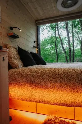 a bed in a room with a large window at Homnest - Infusion Provençale - Lisière & Ocres in Viens