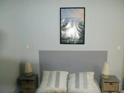 a poster on the wall above a bed with two night stands at Villa in Reillanne with Private Pool in Reillanne