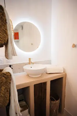 a bathroom with a sink and a mirror at Évasion grecque en duo Suite balnéo Wifi in Carpentras