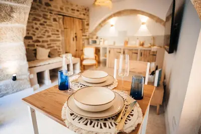 a table with plates and glasses on it in a kitchen at Évasion grecque en duo Suite balnéo Wifi in Carpentras