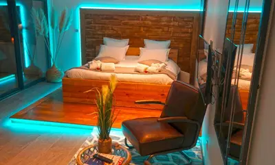 a bedroom with a bed and a chair in a room at Cocon D'amour En Luberon - Chambre Spa a proximite de l'Isle sur la Sorgue in LʼIsle-sur-la-Sorgue