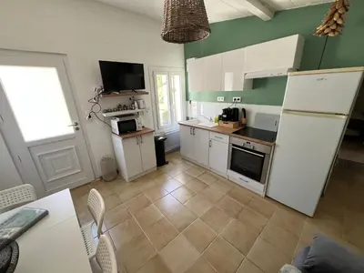 a kitchen with white cabinets and a white refrigerator at Petite maison avec piscine le chêne vert in Gargas