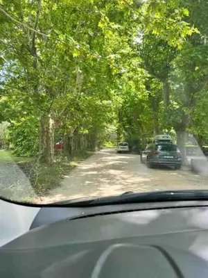 a view from a car window of a road with trees at Au pied du Colorado Provencal in Rustrel