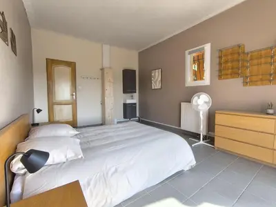 a bedroom with a large white bed and a dresser at La Colline sous les etoiles in Lincel