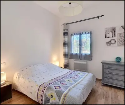 a bedroom with a bed and a dresser and a window at Mon paradis in Maubec