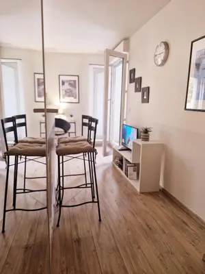 a living room with a table and chairs and a tv at Charmant appart central avec Terrasse & Clim in Aix-en-Provence