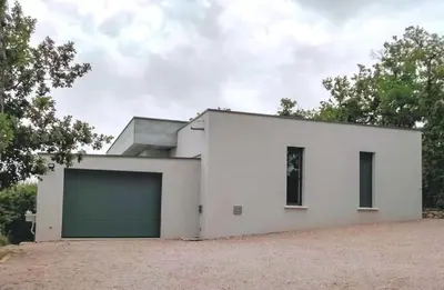 a white house with a garage at Contemporary Villa With Pool In Céreste-En-Luberon in Céreste