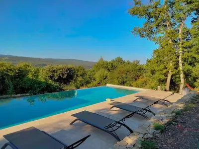 a swimming pool with lounge chairs next to at Contemporary Villa With Pool In Céreste-En-Luberon in Céreste