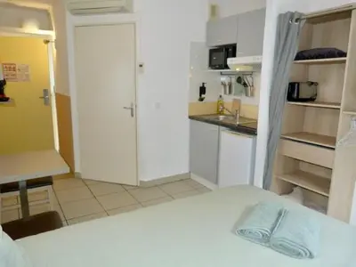 a room with a kitchen and a bed in it at Le Clos d'AIX Studio 113 in Aix-en-Provence