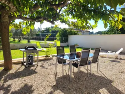 a table and two chairs and a table and a table at Maison BRIALI avec Jacuzzi espace détente in Aubignan