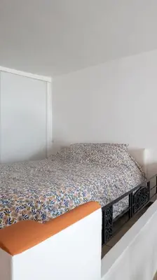 a white bedroom with a bed with an orange mattress at Duplex en centre ville avec un Garage privé in Salon-de-Provence
