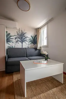 a living room with a couch and a coffee table at Studio climatisé avec terrasse, 5ème étage sans ascenseur in Aix-en-Provence