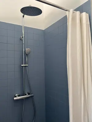 a bathroom with a shower with blue tiles at Maison Poumo, Piscine, clim & padel privé,12 pers in LʼIsle-sur-la-Sorgue