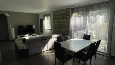 a living room with a couch and a table with chairs at Maison climatisée avec jardin in Caumont-sur-Durance