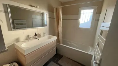 a bathroom with a sink and a tub and a mirror at Maison climatisée avec jardin in Caumont-sur-Durance