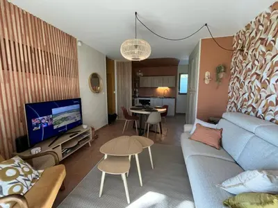 a living room with a blue couch and a table at Golf apartment in Saumane-de-Vaucluse