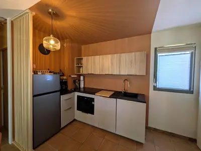 a kitchen with a refrigerator and a sink at Golf apartment in Saumane-de-Vaucluse