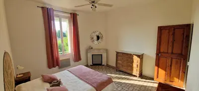a bedroom with a bed and a dresser and a window at Appartement avec extérieur in LʼIsle-sur-la-Sorgue