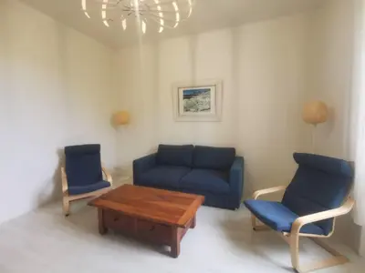 a living room with a blue couch and two chairs at Appartement avec extérieur in LʼIsle-sur-la-Sorgue