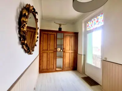 a hallway with a wooden door and a mirror at Appartement avec extérieur in LʼIsle-sur-la-Sorgue