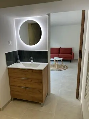 a bathroom with a sink and a mirror and a couch at Suite jacuzzi in Aix-en-Provence