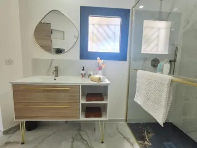 a bathroom with a sink and a shower with a mirror at Ô nuits de saint cannat in Saint-Cannat