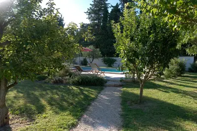 a garden with a bench and a swimming pool at Mas Saint André 3 étoiles au cœur de la Provence in Saint-Andiol