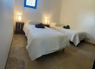 two beds in a room with two lamps on the sides at Mas Saint André 3 étoiles au cœur de la Provence in Saint-Andiol