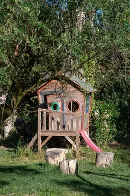 a wooden bird house with a slide in the grass at Mas Saint André 3 étoiles au cœur de la Provence in Saint-Andiol
