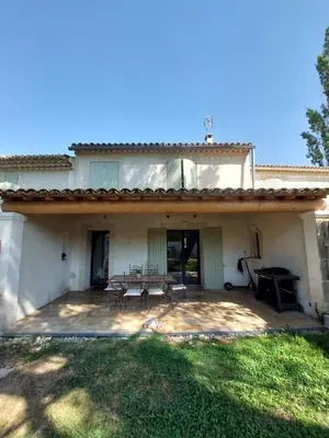 a house with a patio with a table and chairs at Mas Saint André 3 étoiles au cœur de la Provence in Saint-Andiol