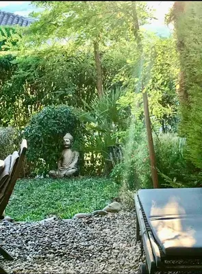 a statue sitting on the ground in a garden at Maison entière avec jardin à 5 mn centre ville Aix en Provence in Aix-en-Provence
