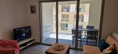 a living room with a television and a balcony at Le Triton, new appartments near city center , parking , lift in Aix-en-Provence
