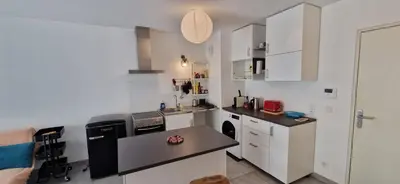 a kitchen with white cabinets and a black counter top at Le Triton, new appartments near city center , parking , lift in Aix-en-Provence
