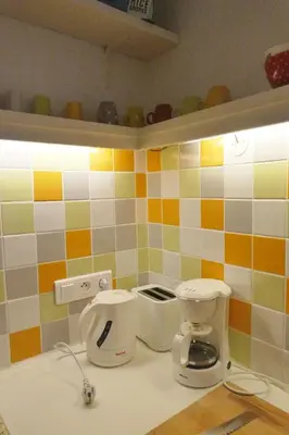 a kitchen with colorful tiles on the wall at La Cachette centre historique village in Roussillon