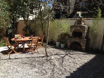a patio with a table and a stone fireplace at La casa du Roy René in Aix-en-Provence