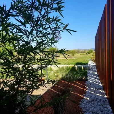 a fence with a tree in front of a field at Le colibri du Luberon in Apt