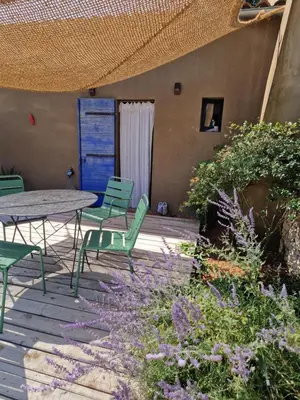 a patio with a table and chairs and flowers at Le colibri du Luberon in Apt