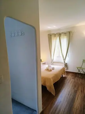 a bedroom with a bed and a large window at Au coeur des ocres in Roussillon